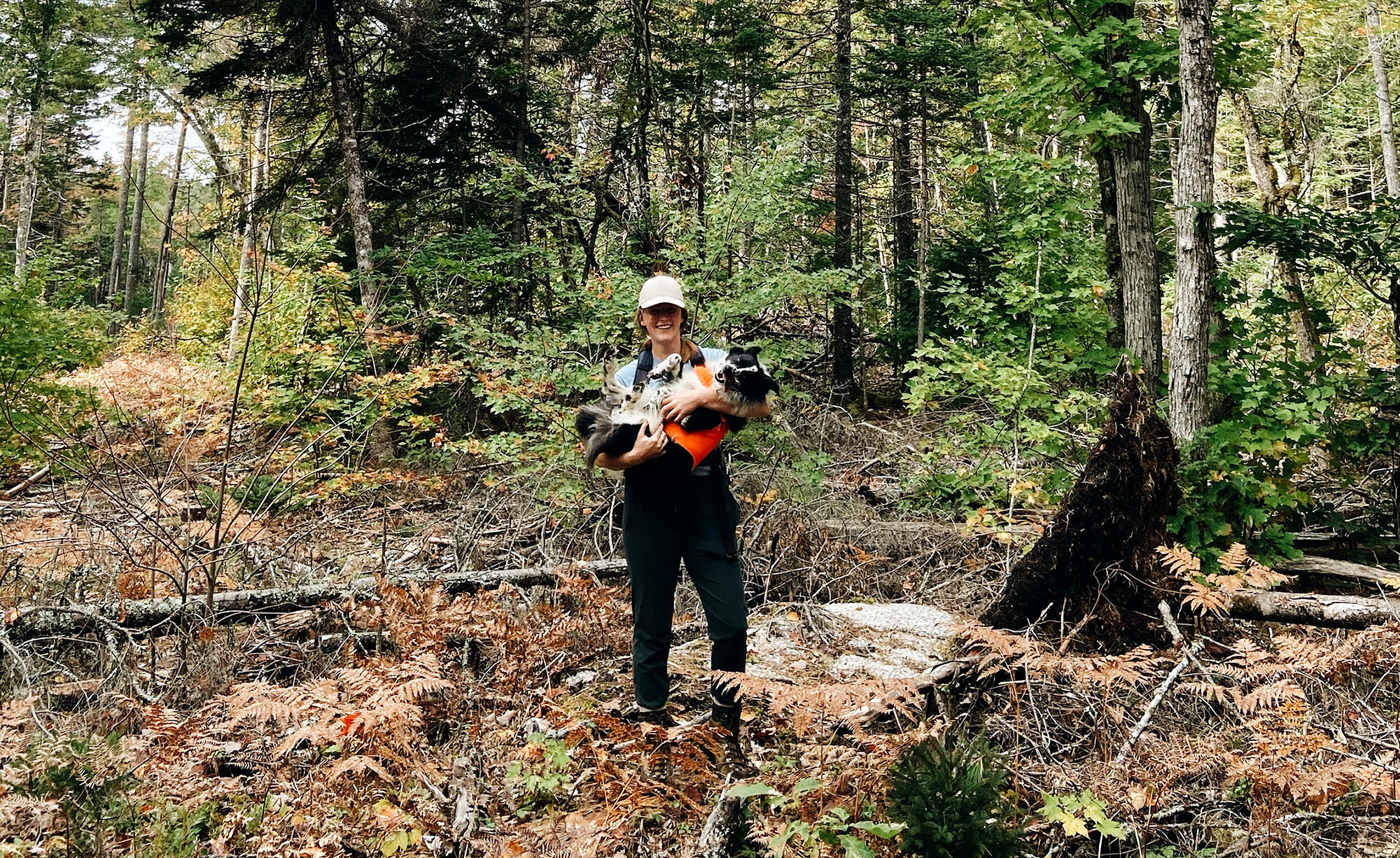 Mary Jane Rodger and her dog standing in the forest.